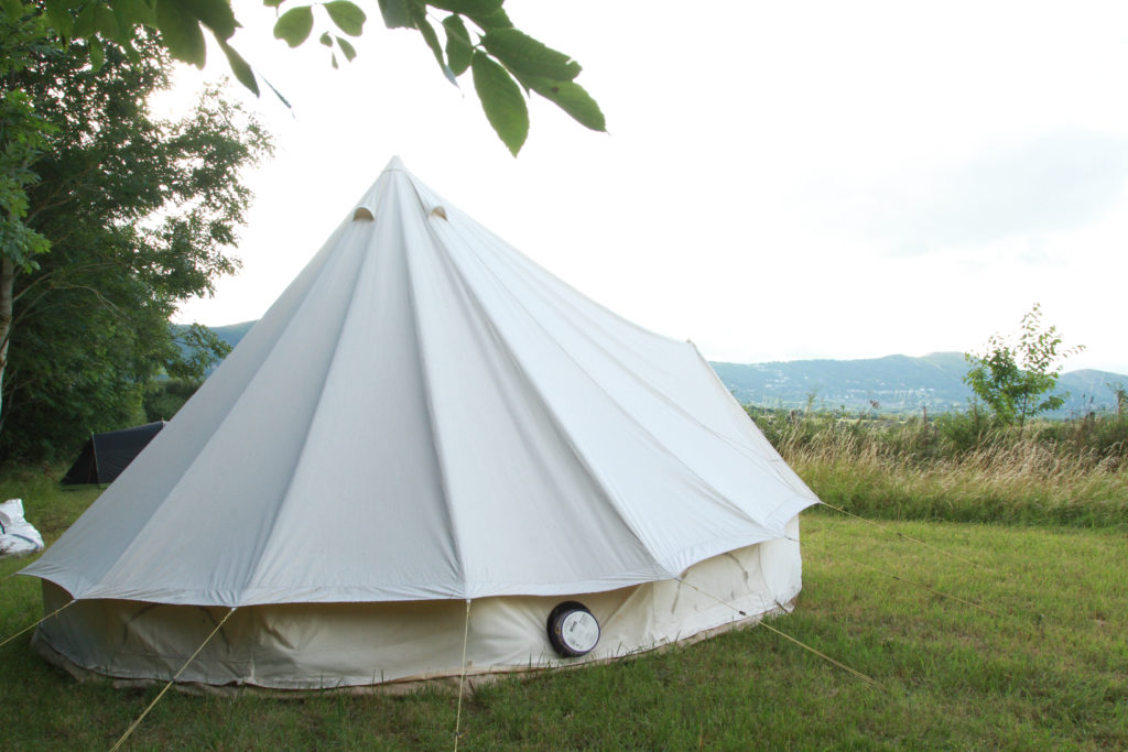 A white canvas bell tent looking out over the Malvern hills
