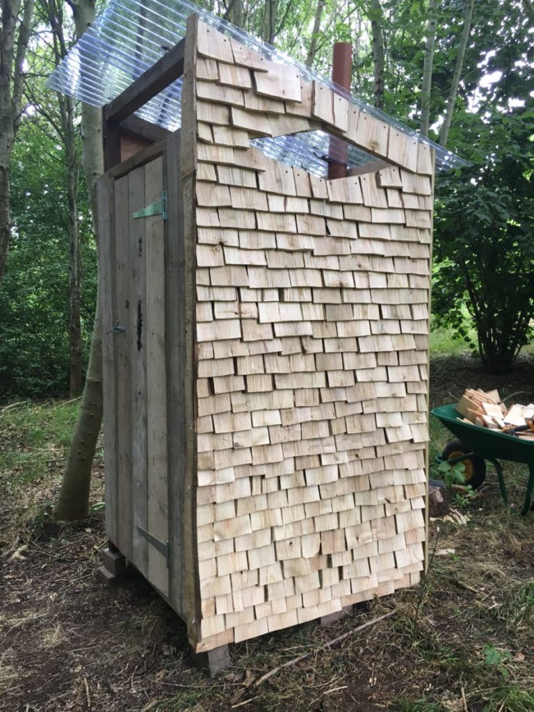 Shingle clad compost loo in the woods